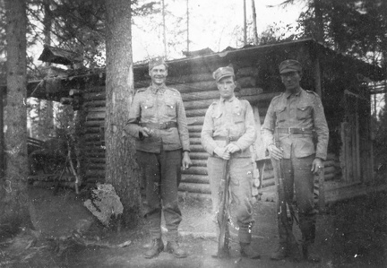 Kolme sotilasta korsun edessä